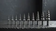 Forets en acier de diamètres croissants alignés sur un rebord en ardoise sombre, sous une lumière grise